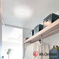 天花板上安裝了一個圓形白色LED小型吸頂燈，燈光柔和。下方是木質層架，層架上擺放著三個黑色收納盒，層架下方掛著一排白色衣物。