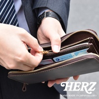 職人手作的深棕色皮革Organ拉鍊長夾，展示內部多個隔層與卡片插槽，拉鍊為金色，車縫線清晰。