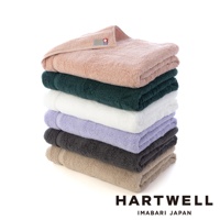 一疊由上至下分別為粉紅色、深綠色、白色、淺紫色、炭灰色和米色六種顏色的今治毛巾，材質看起來為柔軟的棉質，頂端粉紅色毛巾上可見品牌標籤。