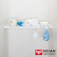 白色伸縮置物掛架，架上擺放著兩捲衛生紙、一個白色網狀籃子內含毛巾與清潔用品、一個藍色清潔工具，以及一個白色小刷子和一瓶藍色噴霧清潔劑。