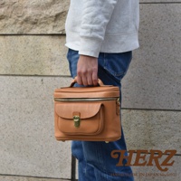 職人手作皮革軟皮相機包 N-6，採用天然棕色皮革製成，設有頂部提把、拉鍊主隔層及前方翻蓋小口袋，搭配金色金屬鎖扣及拉鍊，風格簡約實用。