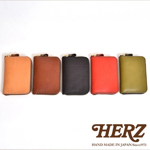 職人手作皮革多用途收納鑰匙包，展示五種顏色：橘棕、咖啡、黑色、紅色、橄欖綠。包款為方形拉鍊設計，材質為皮革，搭配金色拉鍊。