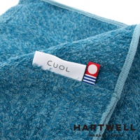藍色紋理毛巾，質地柔軟，有「CUOL」品牌標籤和帶有圓點與條紋的裝飾標籤。