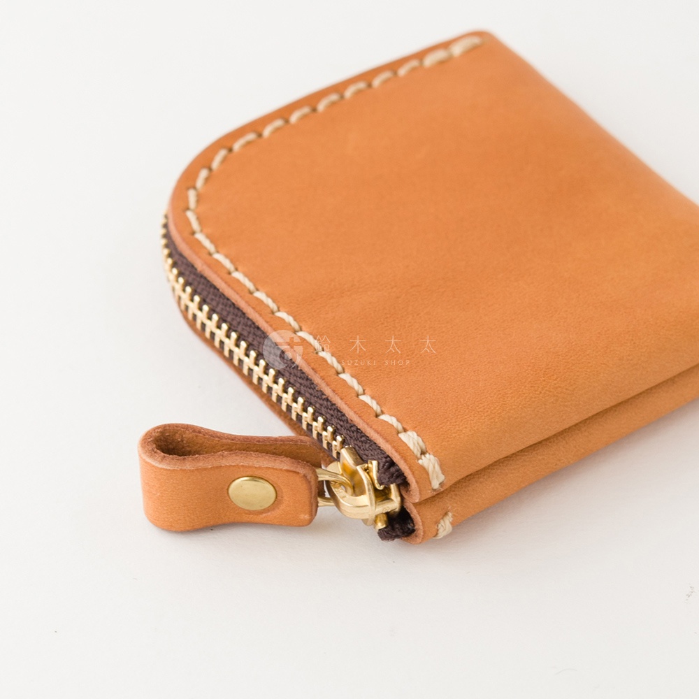 這款日本HERZ職人手作的棕色皮革零錢包，以耐用的Stare皮革製成，表面呈現細膩的質感與手工縫線細節。包身採用L型拉鍊設計，搭配金色金屬拉鍊與皮革拉環，整體風格簡約精緻。