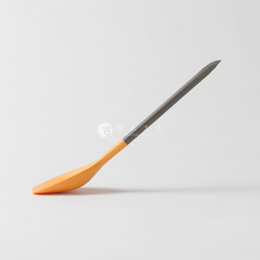 一個橘色和深灰色的斜倚式扁平湯匙，上面有一個淺灰色的品牌標誌和日文文字。