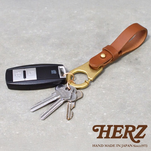 職人手作皮革鑰匙圈，附有汽車遙控器和三把鑰匙。鑰匙圈採用品質皮革製作，搭配黃銅色金屬扣環，設計簡約實用。