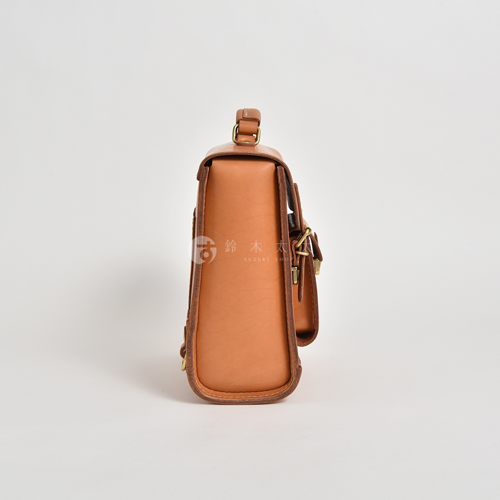 棕色皮革迷你後背包，學院風設計，側面有金屬扣環和皮帶。