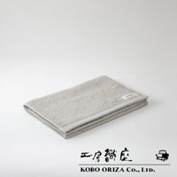 折疊的灰色超細纖維毛巾，觸感柔軟，邊緣縫線清晰，帶有品牌標籤。