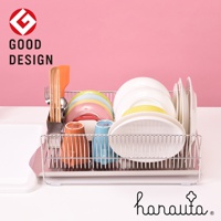 橫放式不鏽鋼碗碟架，包含多個碗盤、彩色杯子、餐具，以及附帶的瀝水盤，整體為銀色金屬材質，背景為粉紅色。