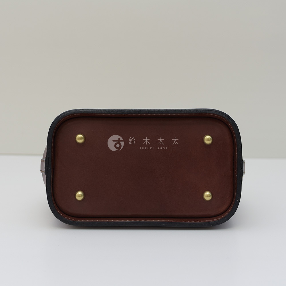 職人手作皮革方型迷你醫生包 CW-106 的底部，咖啡色皮革材質，四個金屬腳釘，以及中間的品牌 Logo。