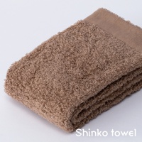 MAISON BLANC 輕奢柔膚匹馬棉毛巾，展現蓬鬆柔軟的紋理，色澤為溫暖的淺褐色，毛巾邊緣帶有細緻的縫線，呈現簡約的設計風格。