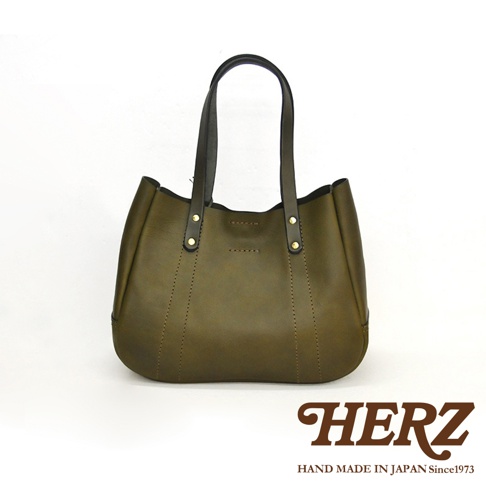 橄欖綠皮革仕女托特包，配有黑色皮革提把，包身縫線細緻，頂部有金屬鉚釘裝飾，整體呈現簡約大方風格。