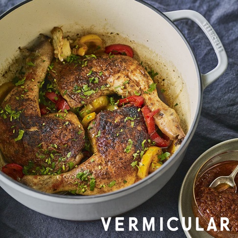 模式B： 裝有烤雞腿、彩椒和香草的琺瑯鑄鐵鍋，旁邊放著一碗醬料，鍋柄上有 VERMICULAR 字樣。
