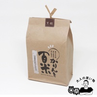 一個站立的牛皮紙袋，頂部有 V 形的紙繩，上面貼著寫有「黑糖」的深棕色標籤。袋子正面有日文和英文的產品標誌，以及一個卡通人物剪影。