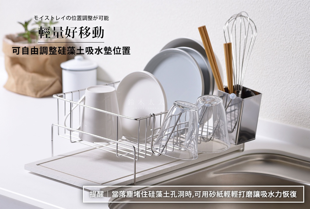 銀色不鏽鋼製成的碗盤餐具瀝水架，架上擺放著白色馬克杯、玻璃杯、盤子和竹筷。瀝水架下方有一塊淺灰色的珪藻土吸水墊。