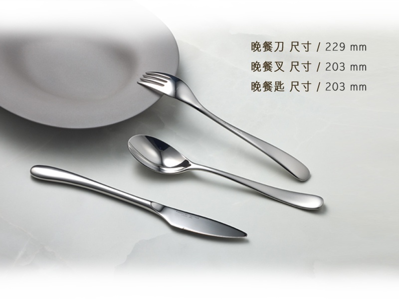 銀色霧面不鏽鋼晚餐刀、晚餐叉和晚餐匙，旁邊擺放著一個白色餐盤。