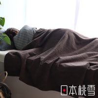 一條深棕色的雙面毛圈長棉毛巾被，覆蓋在一位睡著的人身上，毛巾被材質柔軟，呈現自然的褶皺。