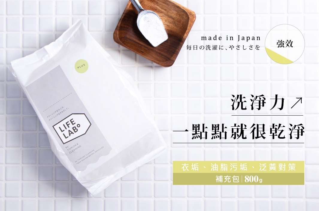 白色補充包裝洗衣粉，上面印有「LIFE LAB°」標誌和日文說明。旁邊有一個木製小碟，裝有銀色勺子。背景為白色格紋磁磚。