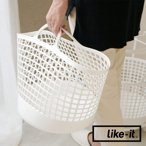 一個白色網格透氣的塑膠洗衣籃，帶有兩個提把，由一位女士拿著，背景有另一個同款洗衣籃。