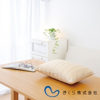 淺米色條紋純棉枕套的柔彈午睡枕，置於木桌上，旁邊有眼鏡和打開的書本。