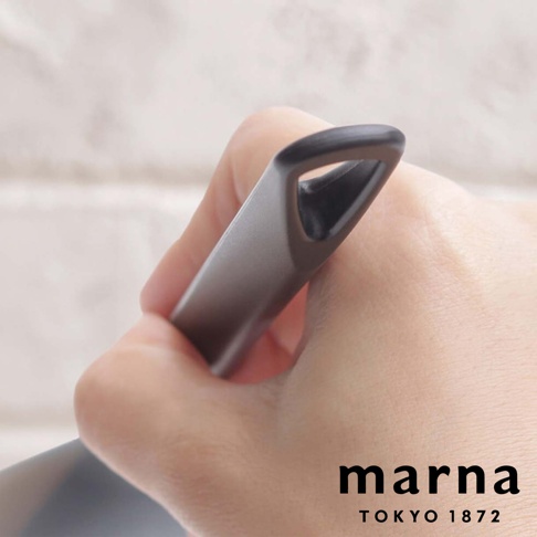 marna TOKYO 1872 標誌，旁邊是手持灰色調理器具的特寫，背景是淺色磚牆