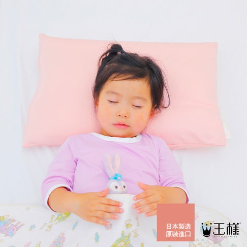 粉紅色枕頭上，一名睡著的小女孩穿著紫色長袖衣，懷裡抱著兔子玩偶，蓋著印有可愛圖案的被子。