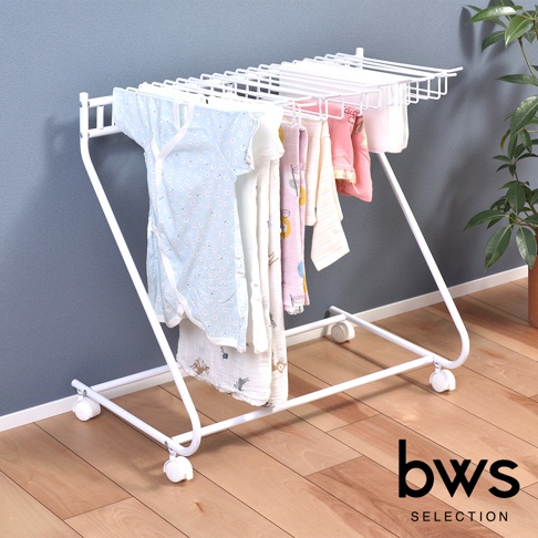 白色多功能落地移動褲架，金屬材質，帶有輪子，上方掛有藍色、粉色、白色等多件嬰幼兒衣物及毛巾，整體設計簡潔實用。