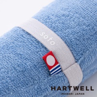 一條捲起的藍色毛巾，上面繫著白色束帶，束帶上印有 soto 字樣。毛巾材質柔軟，細節處可見今治印花。