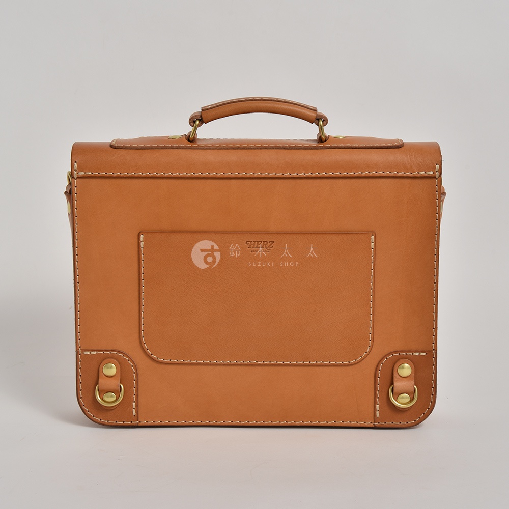 棕色皮革製成的歐風三用學生包，有頂部提把、正面翻蓋口袋及金屬扣環，縫線清晰，質感佳。