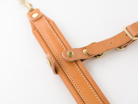 職人手作皮革背包用減壓胸前扣帶，淺棕色皮革，配有黃銅色五金扣件和縫線。