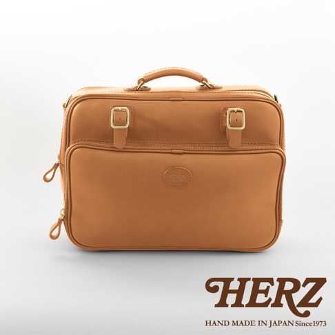 棕色皮革兩用商務公事包，配有頂部提把、側邊拉鍊、前後隔層、兩個金色搭扣及品牌壓紋標誌。