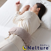 一名女子側臥在床上，腰部配戴著可調式今治毛巾材質腰枕，腰枕呈現淺褐色，材質柔軟蓬鬆。