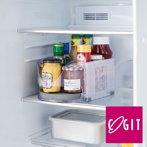 透明塑膠製的多功能橢圓旋轉調味收納盤，盤中放置多瓶醬料罐，包含黃芥末醬、果醬、番茄醬等，底部有灰色防滑墊，可旋轉方便拿取。