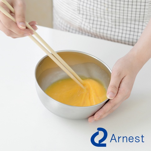 Arnest 防刮不鏽鋼調理碗，使用筷子攪拌碗中的蛋液。