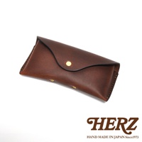 一個棕色皮革眼鏡收納盒，帶有金色鉚釘和品牌標誌。