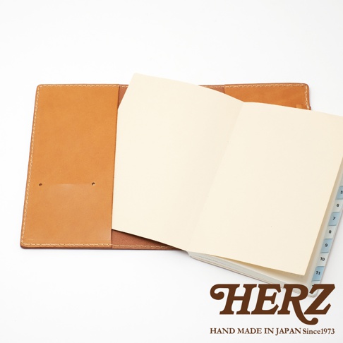 職人手作皮革B6記事本書套，淺棕色皮革，內含一本淺色內頁筆記本，筆記本有標示數字的索引隔頁。