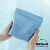 雙手捧著一袋淺藍色、霧面質感的 ASUNO 無香料溫和中性洗衣粉包裝。包裝上有白色字體標示「LAUNDRY POWDER」及日文說明，以及「a s u n o」的字母設計。