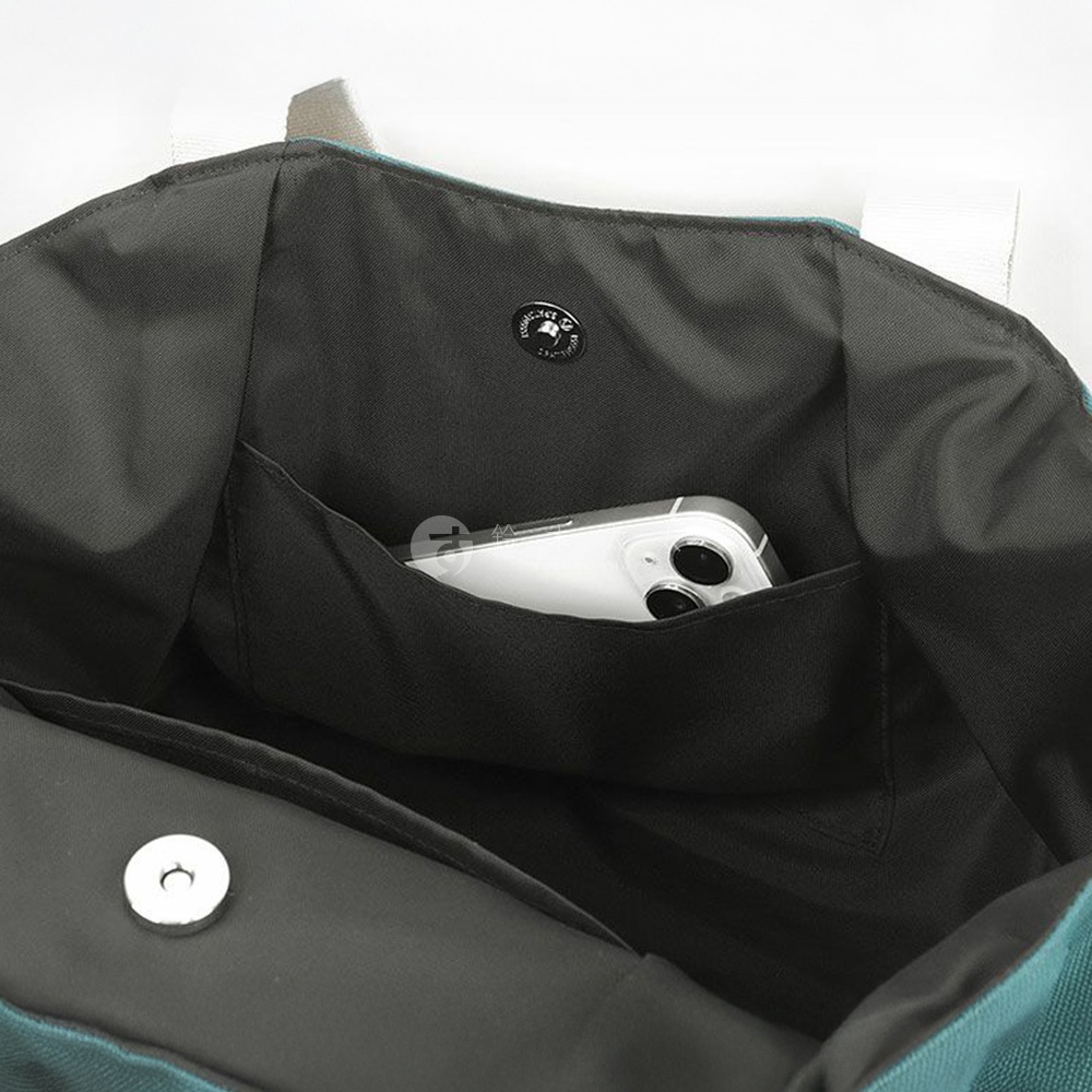 包包內部特寫，有一個黑色內袋，裡面放著一部白色手機，旁邊有品牌標誌。