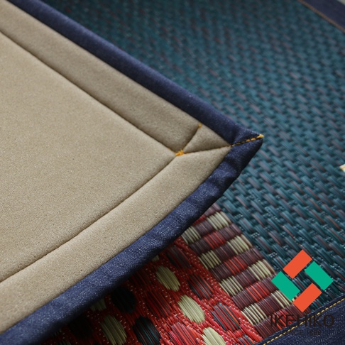 RALPH 藺草和風居家地墊 M，採用深藍色牛仔布包邊，內層為米色材質，表面有菱形格紋縫線，整體呈現藺草編織紋理，色調以藍綠色、紅色、棕色和米色為主。