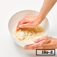 白色簡約雙層瀝水籃，籃身有多孔設計，籃內裝有米粒，兩隻手正在清洗米粒。