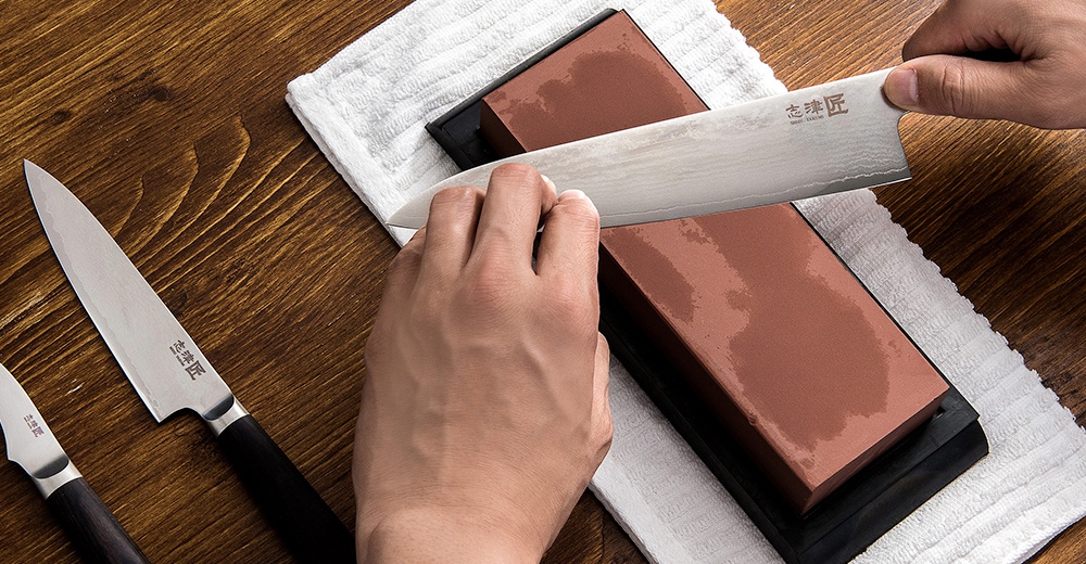 志津匠的刀具在磨刀石上進行打磨，展現其精湛的工藝。