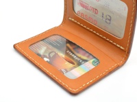 職人手作皮革雙折票券收納夾，淺棕色皮革，車縫線清晰，內含透明視窗，展示星巴克卡與 PASMO 交通卡。