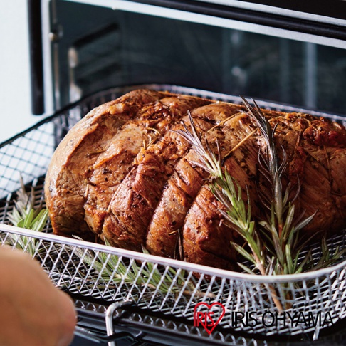 剛出爐的烤肉，表面金黃焦香，用繩子綑綁，擺放在金屬網籃中，搭配新鮮迷迭香，置於烤箱內。