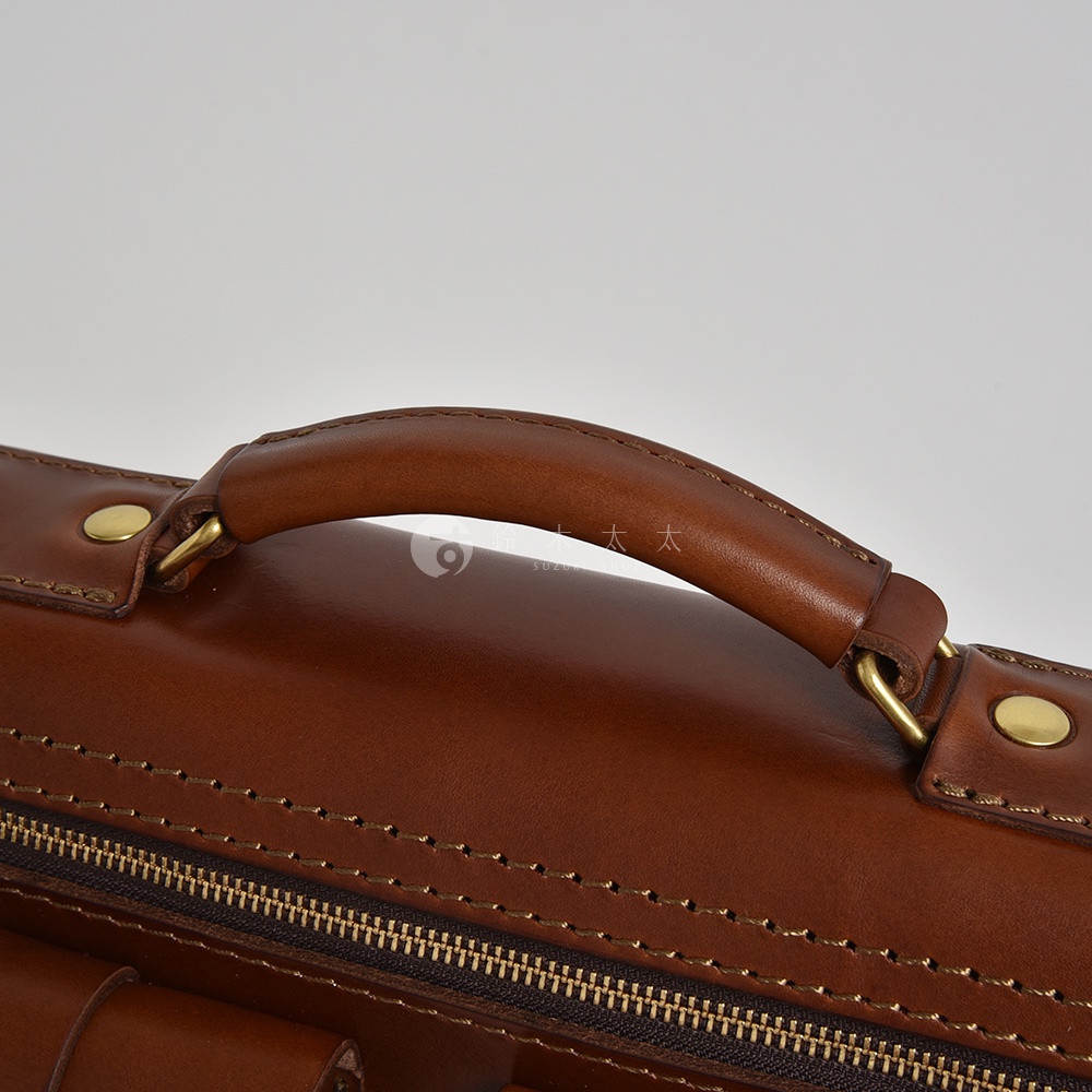 職人手作皮革雙口袋兩用單肩包 A-19，採用棕色皮革，配有金屬拉鍊、銅扣及提把，展現精緻工藝。