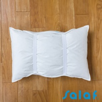 純白色枕套，表面有垂直縫線，兩側各有一條白色鬆緊帶，枕套置於木紋地板上。