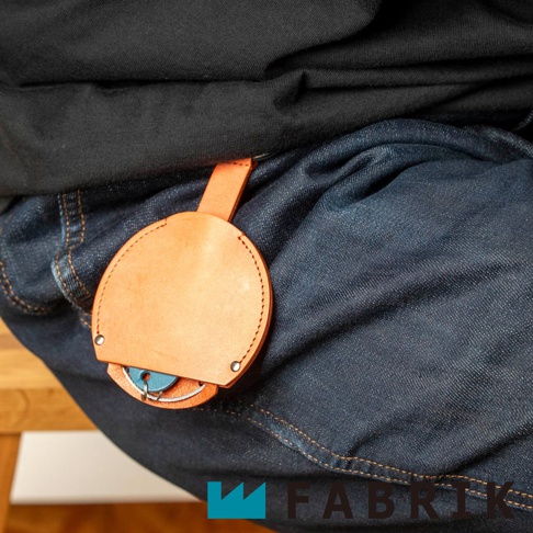 FABRIK 皮革圓形收納鑰匙圈掛在牛仔褲上，展示可收納的鑰匙。