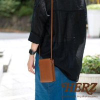 棕色皮革手機包，採用職人手作工藝，簡約設計，可斜肩或側背。