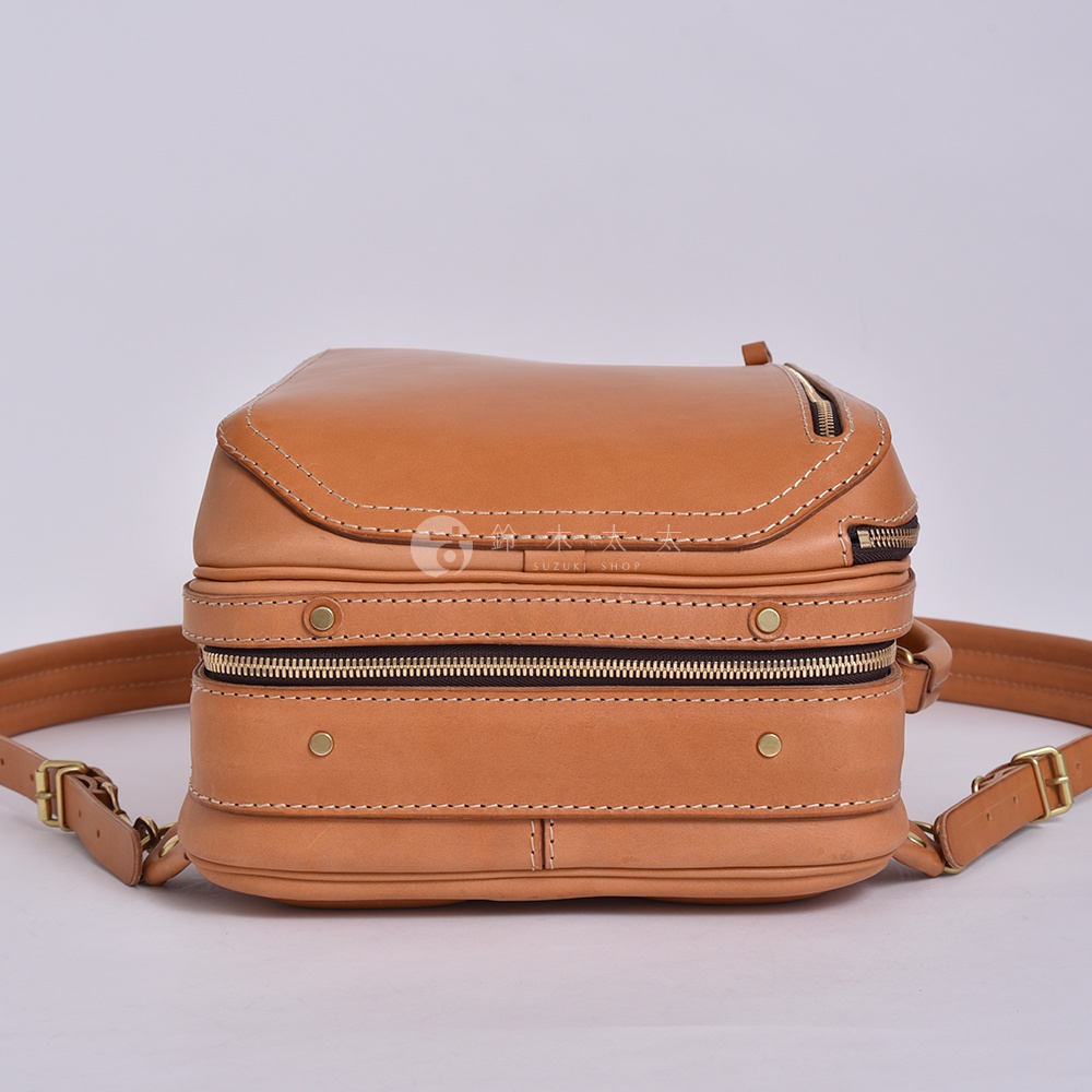 職人手作皮革兩用商務後背包，淺棕色，正面有兩條拉鍊、銅質鉚釘裝飾，搭配皮革背帶。