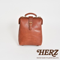 一款棕色皮革迷你軟皮杜勒斯包，帶有金色搭扣和提把，產品標誌為HERZ，Hand Made in Japan Since 1973。