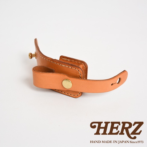 淺棕色皮革製成的腰間小物收納包，採用職人手作工藝，設有原子釦開合與皮帶固定設計，可夾於腰帶上，方便收納。